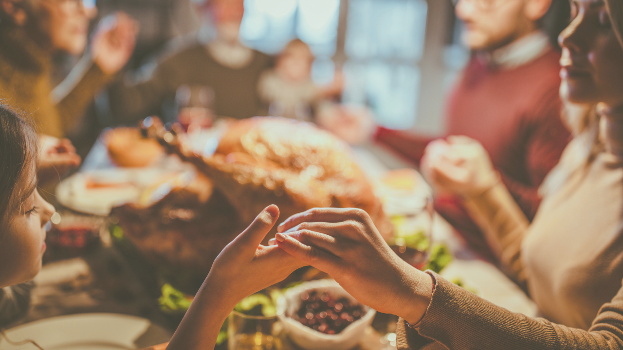 Family gathered around a Thanksgiving dinner table, celebrating gratitude and abundance with a joyful, connected meal